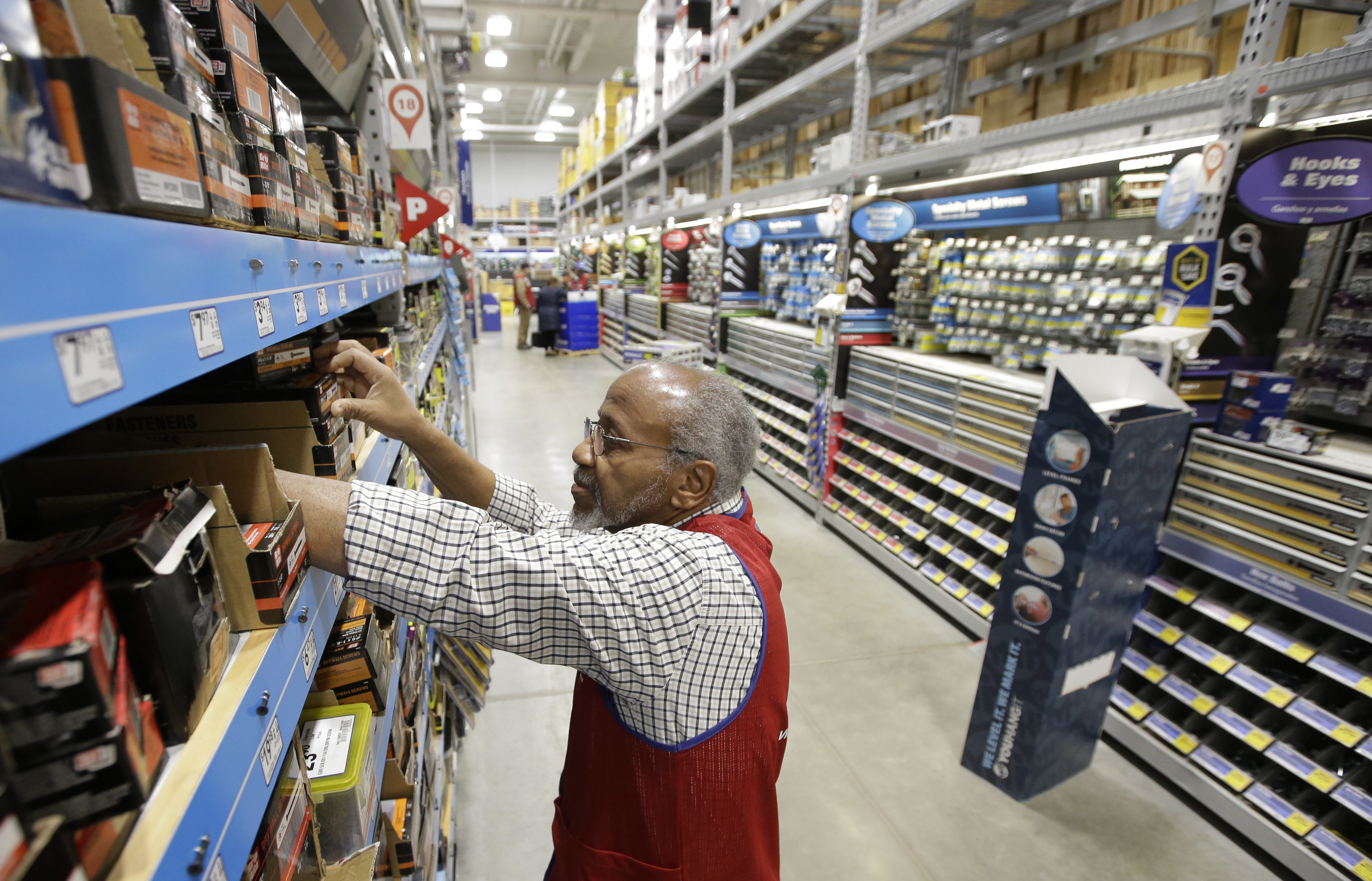 Photo sales associate Larry Wardford, of Holliston, Mass., places items on selves at a Lowe's retail home improvement and appliance store, in Framingham, Mass. Lowe's Companies, Inc. reports financial results. AP Photo by Steven Senne