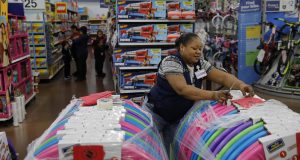 In this Nov. 27, 2019, file photo Balo Balogun labels items in preparation for a holiday sale at a Walmart Supercenter in Las Vegas. On Friday, the U.S. government issued the November jobs report. AP Photo by John Locher